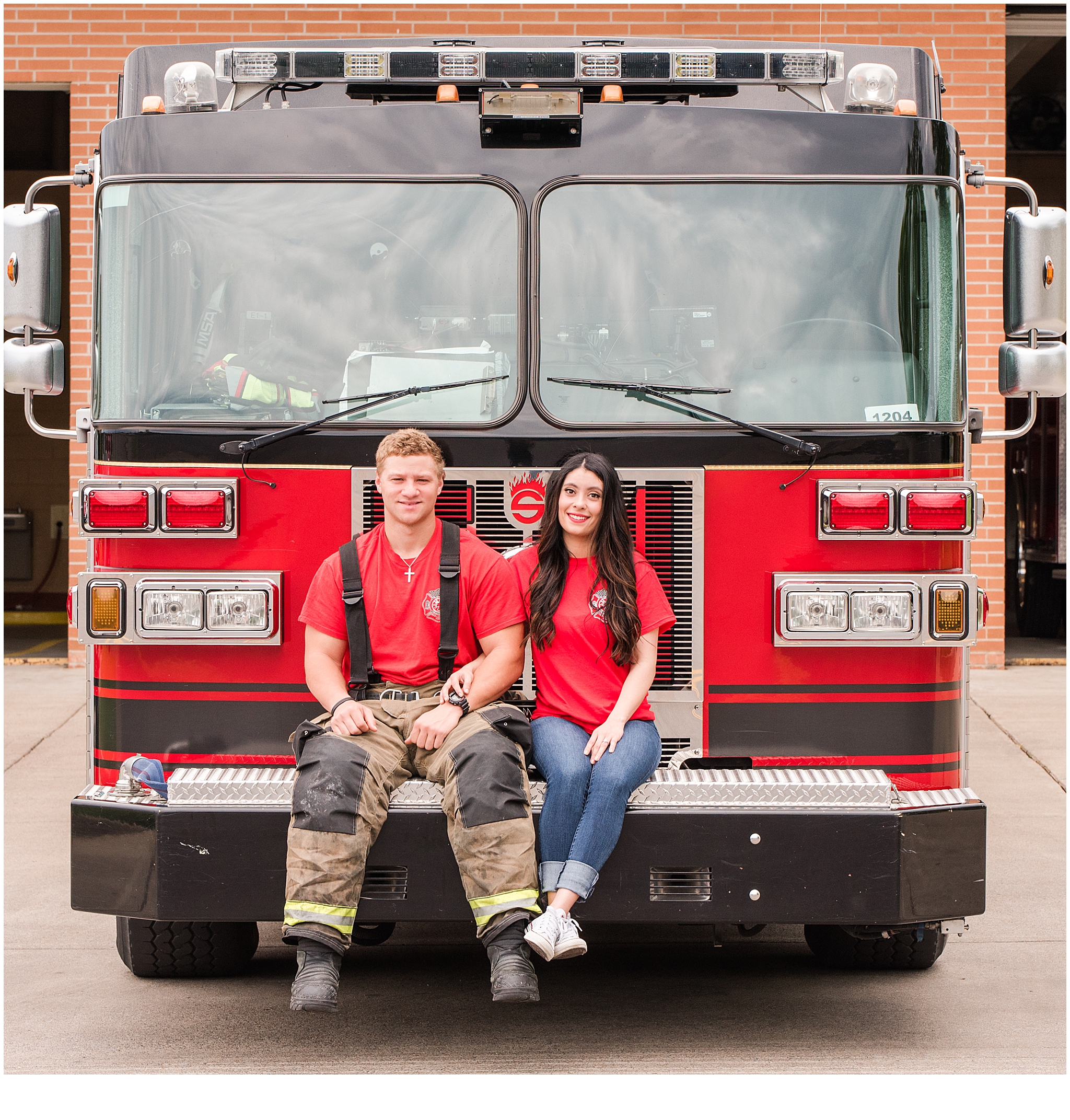 Engaged couple sitting on the front of a fire engine during their engagement session. Neely Roberts Photography.