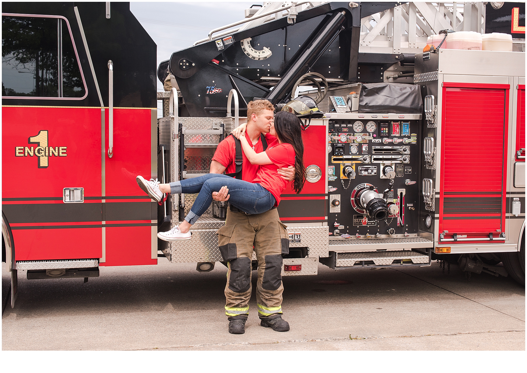 Engaged couple kissing in front of a fire engine during their engagement session. Neely Roberts Photography.