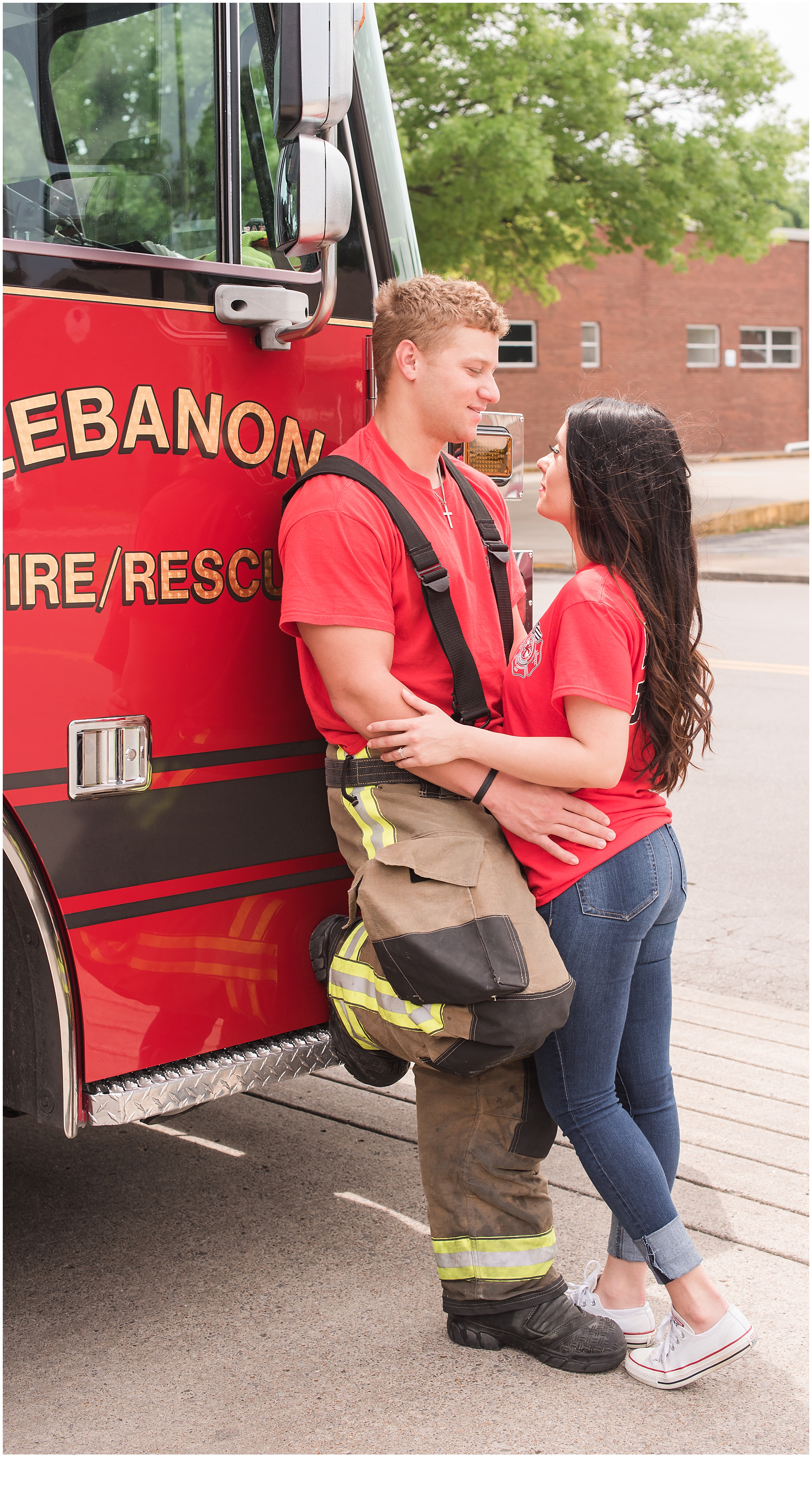 Engaged couple leaning against a fire engine during their engagement session. Neely Roberts Photography.