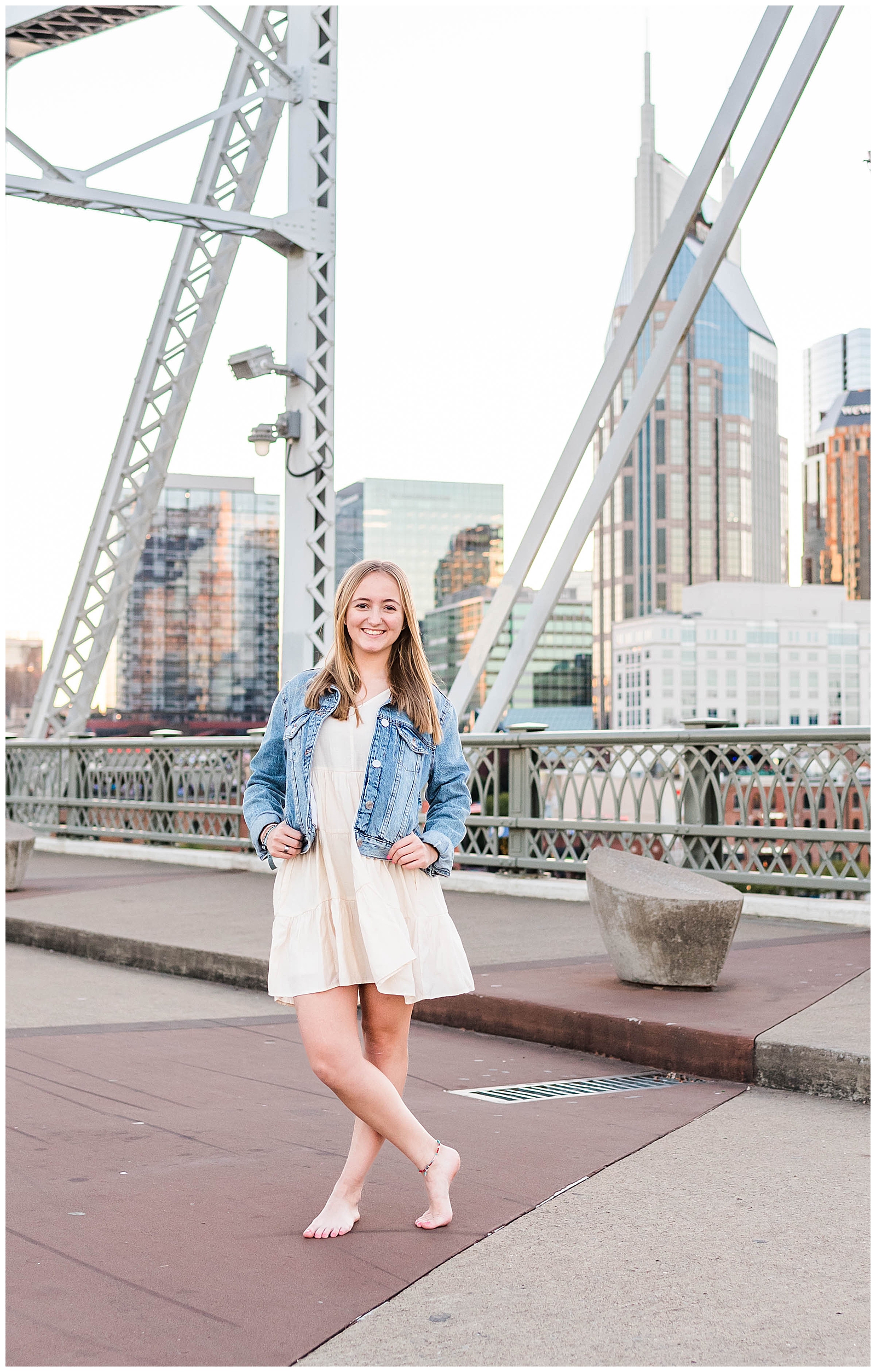 High school senior girl, standing with her legs crossed, on the Nashville Pedestrian Bridge in Downtown Nashville, TN
