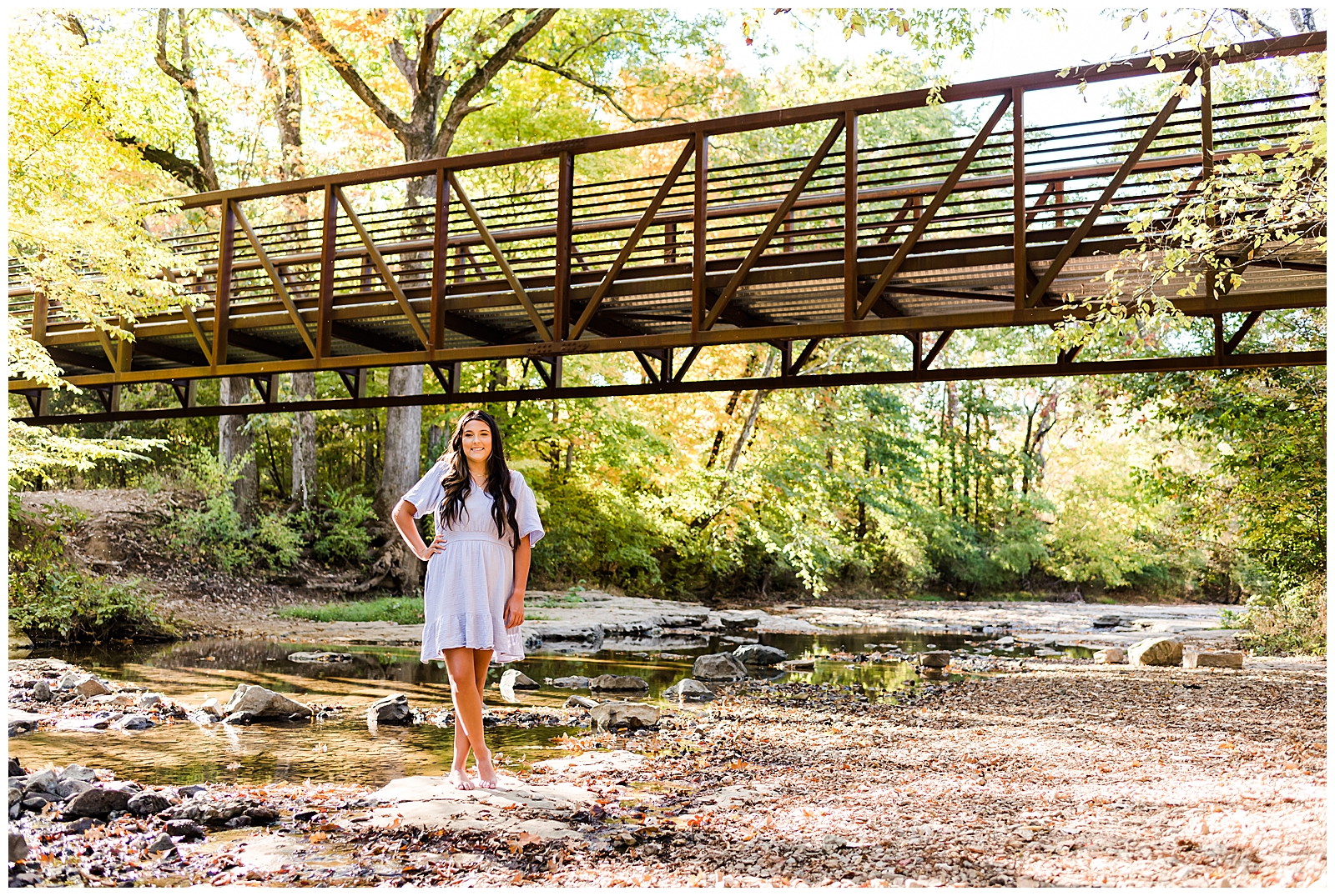 High school senior girl wearing a lavender-colored dress, standing in the creek, in Hendersonville, TN.