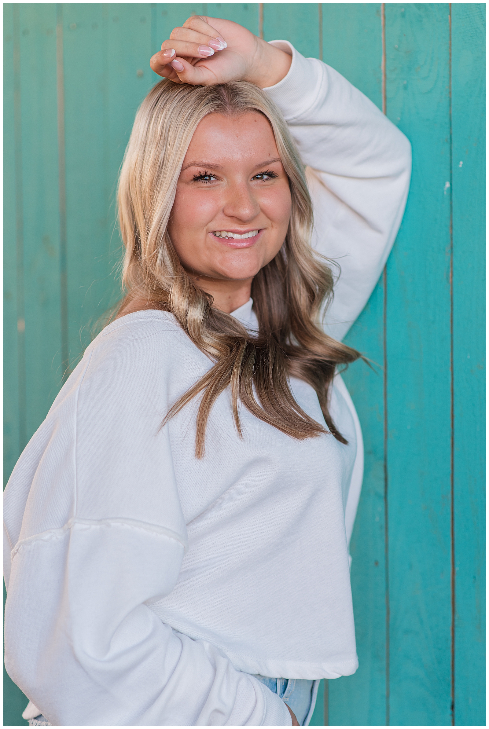 High school senior girl, leaning against a teal wall, in Mt. Juliet, TN