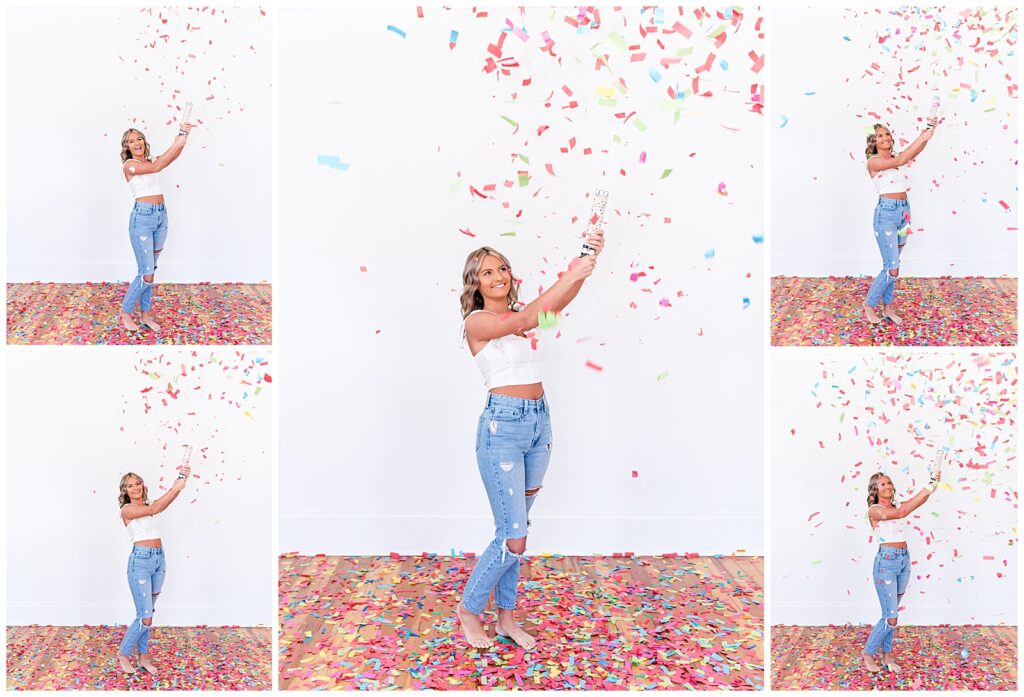 A high school senior spokesmodel wearing jeans and a white crop top laughs as she pops a confetti cannon for photos. 