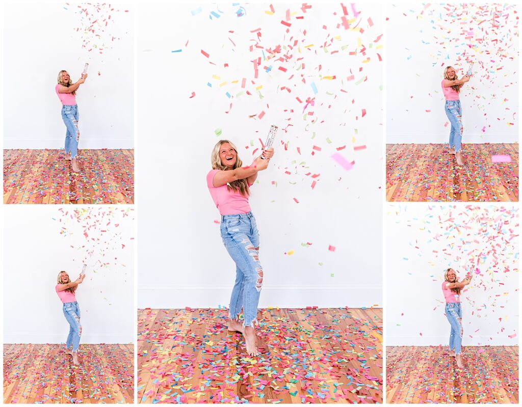 A high school senior spokesmodel wearing jeans and a pink top laughs as she pops a confetti canon for photos. 