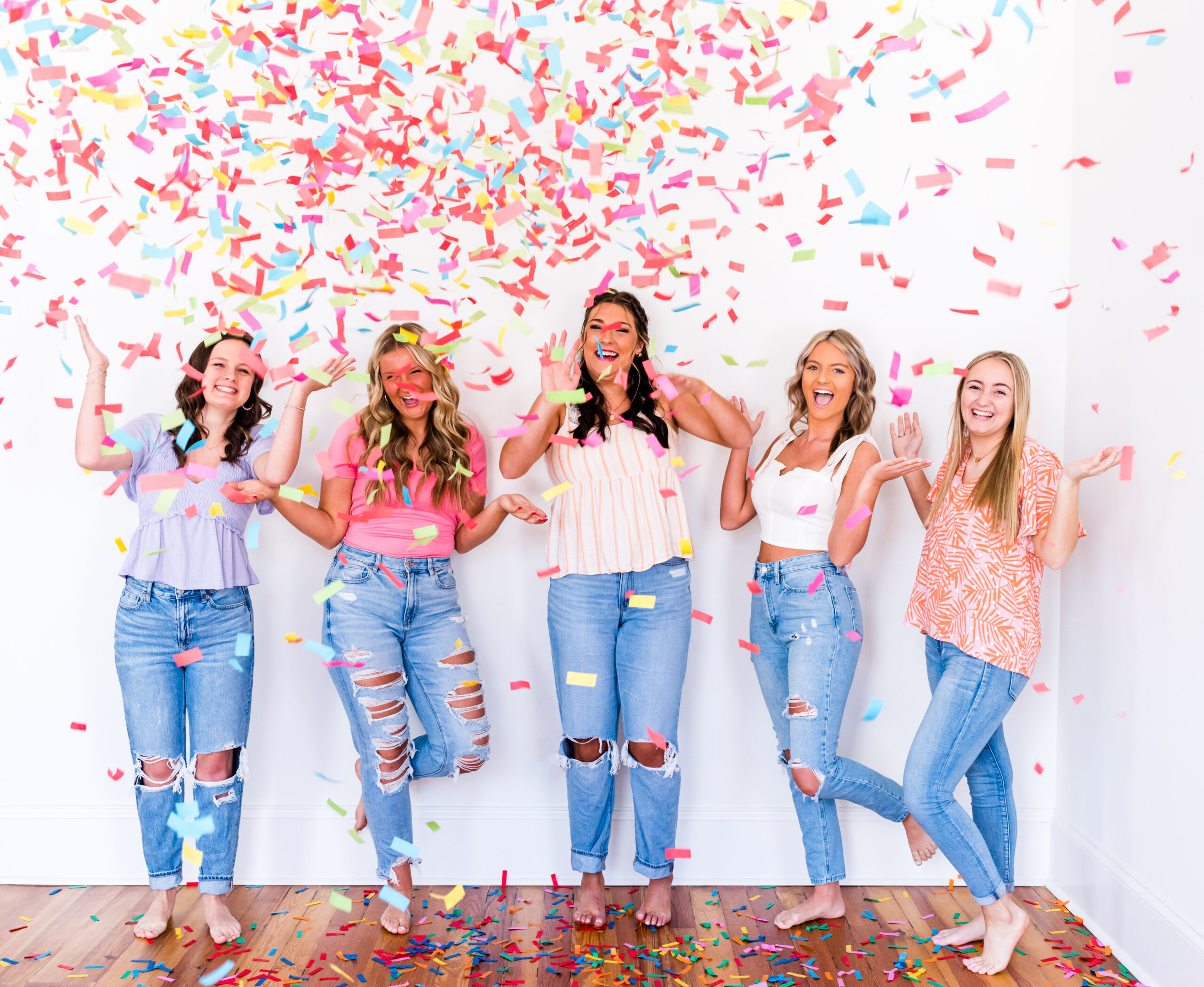 High school senior girls pop confetti cannons in a fun studio photo session.