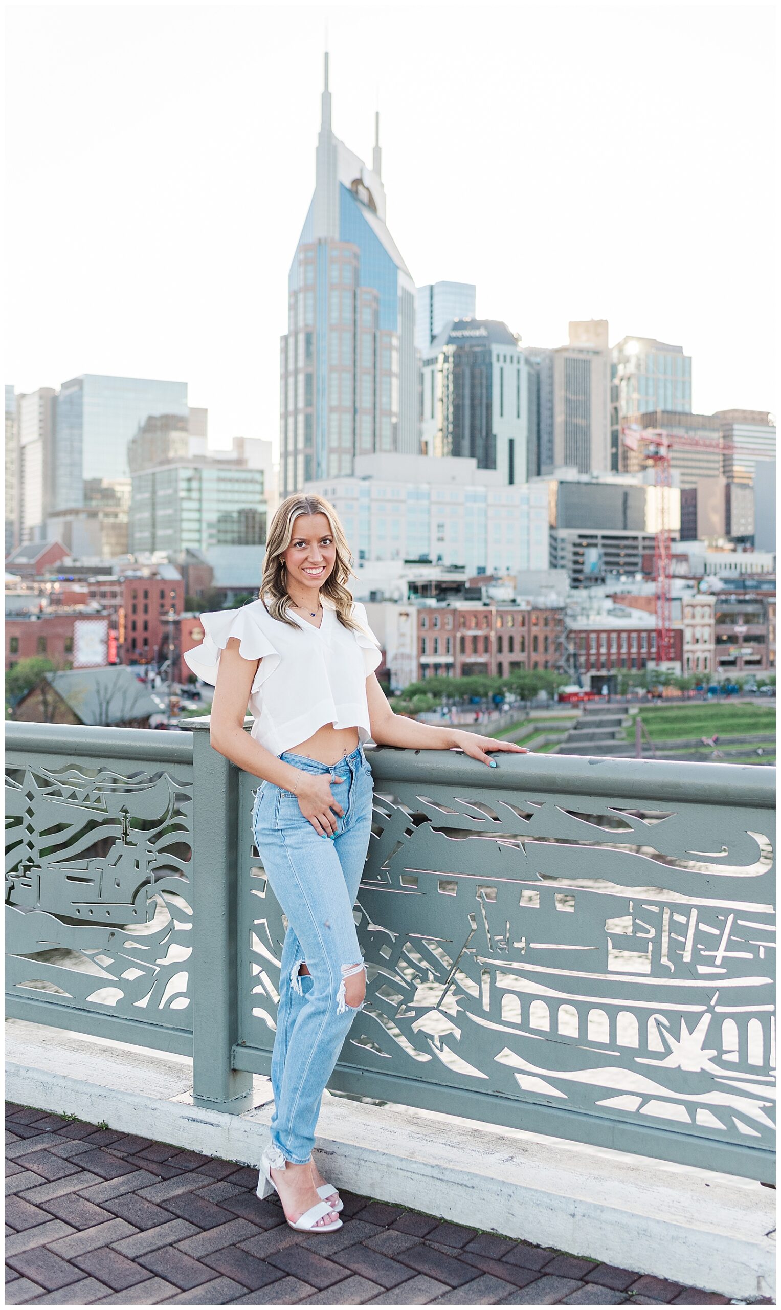 High school senior girl standing on the Nashville Pedestrian Bridge for her senior photos.